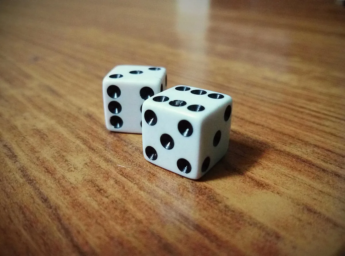 Two dice on a table showing a six and a five
