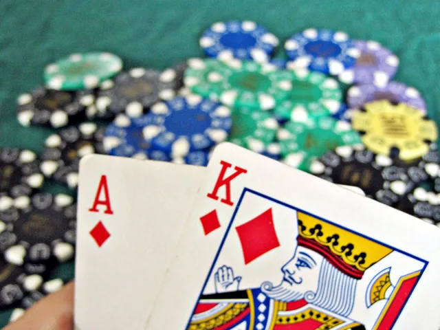 Ace and king held over stacks of casino chips