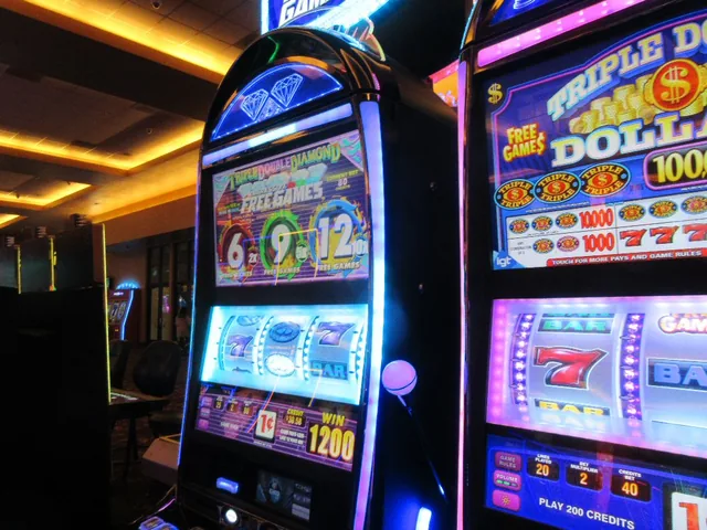 Row of lit-up slot machines in a casino